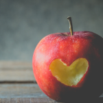 Red Apple with Heart-Shaped Cut on Rustic Table