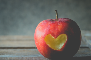 Red Apple with Heart-Shaped Cut on Rustic Table